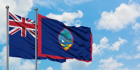 New Zealand and Guam flag waving in the wind against white cloudy blue sky together. Diplomacy concept, international relations.