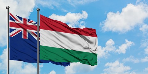 New Zealand and Hungary flag waving in the wind against white cloudy blue sky together. Diplomacy concept, international relations.