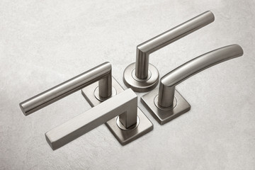 Composition of door handles on a gray background.