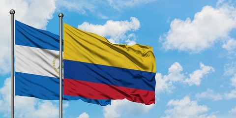 Nicaragua and Colombia flag waving in the wind against white cloudy blue sky together. Diplomacy concept, international relations.