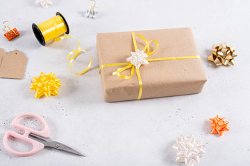 Flat lay with present, wrapping paper, ribbon, bow and scissors on white background
