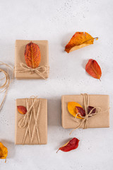 Autumn creative holiday presents. Craft paper gift box decorated with dried leaves. Thanksgiving day, birthday, fall background. Top view