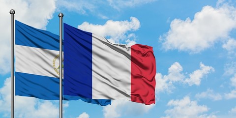 Nicaragua and France flag waving in the wind against white cloudy blue sky together. Diplomacy concept, international relations.