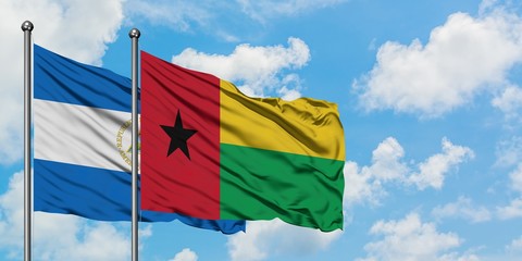 Nicaragua and Guinea Bissau flag waving in the wind against white cloudy blue sky together. Diplomacy concept, international relations.