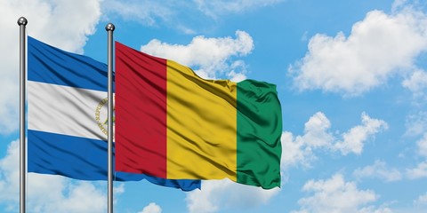 Nicaragua and Guinea flag waving in the wind against white cloudy blue sky together. Diplomacy concept, international relations.