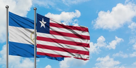 Nicaragua and Liberia flag waving in the wind against white cloudy blue sky together. Diplomacy concept, international relations.
