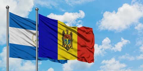 Nicaragua and Moldova flag waving in the wind against white cloudy blue sky together. Diplomacy concept, international relations.