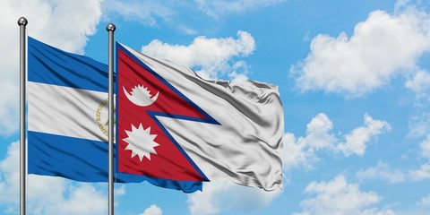Nicaragua and Nepal flag waving in the wind against white cloudy blue sky together. Diplomacy concept, international relations.