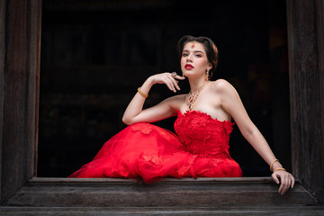 Beautiful portrait of young Asian woman in traditional Hindu red sari wedding clothes with bride dressed makeup and jewelery gorgeous brunette bride. Concept Indian costume