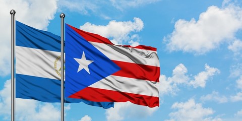 Nicaragua and Puerto Rico flag waving in the wind against white cloudy blue sky together. Diplomacy concept, international relations.