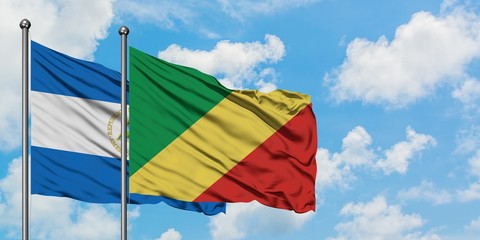 Nicaragua and Republic Of The Congo flag waving in the wind against white cloudy blue sky together. Diplomacy concept, international relations.
