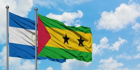 Nicaragua and Sao Tome And Principe flag waving in the wind against white cloudy blue sky together....