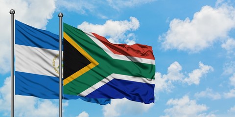 Nicaragua and South Africa flag waving in the wind against white cloudy blue sky together. Diplomacy concept, international relations.
