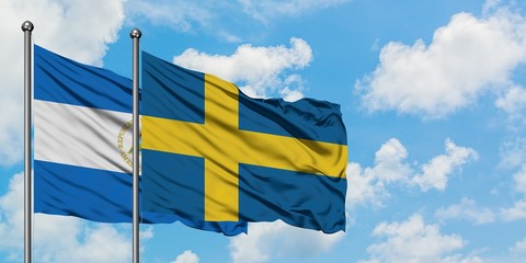 Nicaragua and Sweden flag waving in the wind against white cloudy blue sky together. Diplomacy concept, international relations.