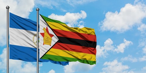 Nicaragua and Zimbabwe flag waving in the wind against white cloudy blue sky together. Diplomacy concept, international relations.