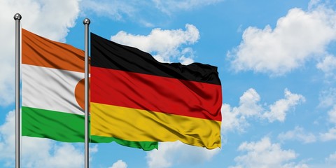 Niger and Germany flag waving in the wind against white cloudy blue sky together. Diplomacy concept, international relations.