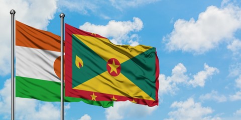 Niger and Grenada flag waving in the wind against white cloudy blue sky together. Diplomacy concept, international relations.