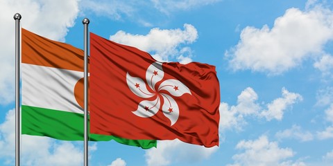 Niger and Hong Kong flag waving in the wind against white cloudy blue sky together. Diplomacy concept, international relations.