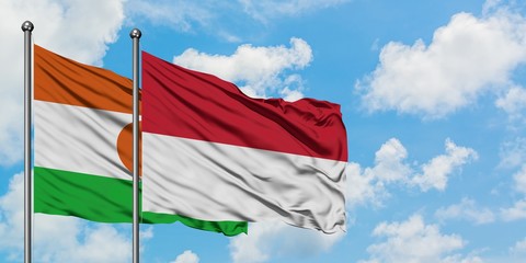 Niger and Indonesia flag waving in the wind against white cloudy blue sky together. Diplomacy concept, international relations.