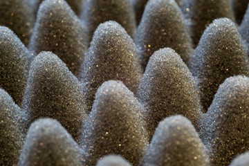 Dark artificial foam, acoustic foam insulation texture on background.