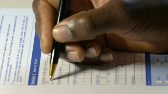 african migrant man's hand filling immigrant petition.immigration,asylum
