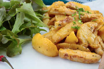 fried potatoes and chicken with salad on a plate