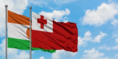 Niger and Tonga flag waving in the wind against white cloudy blue sky together. Diplomacy concept, international relations.