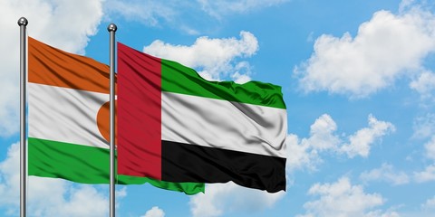 Niger and United Arab Emirates flag waving in the wind against white cloudy blue sky together. Diplomacy concept, international relations.