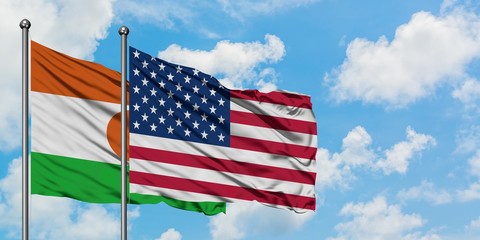 Niger and United States flag waving in the wind against white cloudy blue sky together. Diplomacy concept, international relations.