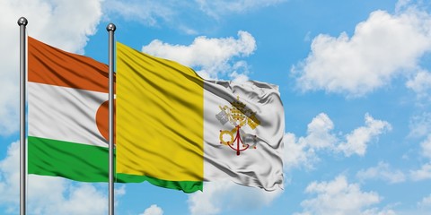 Niger and Vatican City flag waving in the wind against white cloudy blue sky together. Diplomacy concept, international relations.