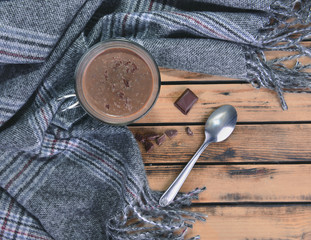 top view on a mug of hot chocolate with scarf on a wooden table