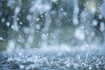 Fotobehang blue color tone of close up rain water drop falling to the floor in rainy season  © กรบุรษ วรดี