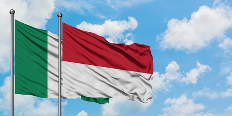 Nigeria and Monaco flag waving in the wind against white cloudy blue sky together. Diplomacy...