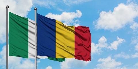 Nigeria and Romania flag waving in the wind against white cloudy blue sky together. Diplomacy concept, international relations.