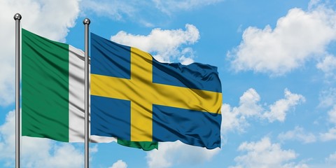 Nigeria and Sweden flag waving in the wind against white cloudy blue sky together. Diplomacy concept, international relations.