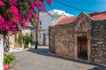 Kritsa traditional cretan village with stone built church, narrow alley and houses with bougainvilleas, near Agios Nikolaos. Crete, Greece 