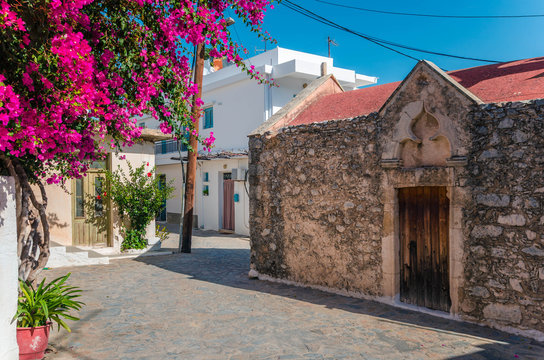 Kritsa traditional cretan village with stone built church, narrow alley and houses with bougainvilleas, near Agios Nikolaos. Crete, Greece 