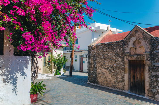 Kritsa traditional cretan village with stone built church, narrow alley and houses with bougainvilleas, near Agios Nikolaos. Crete, Greece 
