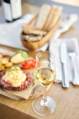 Roasted octopus BBQ and Baked potato with a glass of Grapa. Wooden plate. Restaurant menu