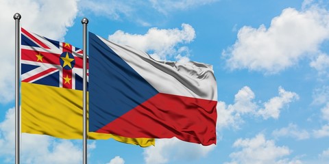 Niue and Czech Republic flag waving in the wind against white cloudy blue sky together. Diplomacy...