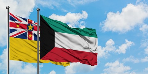 Niue and Kuwait flag waving in the wind against white cloudy blue sky together. Diplomacy concept, international relations.