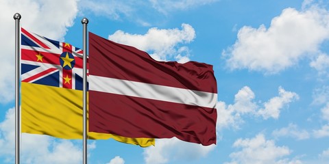 Niue and Latvia flag waving in the wind against white cloudy blue sky together. Diplomacy concept,...
