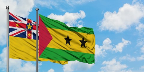Niue and Sao Tome And Principe flag waving in the wind against white cloudy blue sky together....