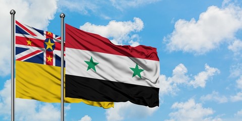 Niue and Syria flag waving in the wind against white cloudy blue sky together. Diplomacy concept, international relations.