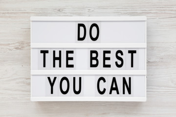 Obraz premium 'Do the best you can' words on a lightbox on a white wooden background, top view. Overhead, from above, flat lay.