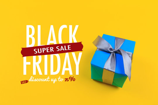Gift box with ribbon and bow on color background and space for text.Black friday sale - Image