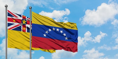 Niue and Venezuela flag waving in the wind against white cloudy blue sky together. Diplomacy concept, international relations.
