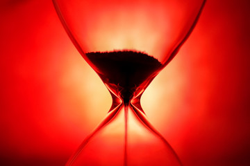 Crystal Hourglass on red background, inspirational time pass concept 