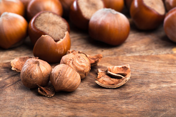 close up of hazelnuts on wooden table .