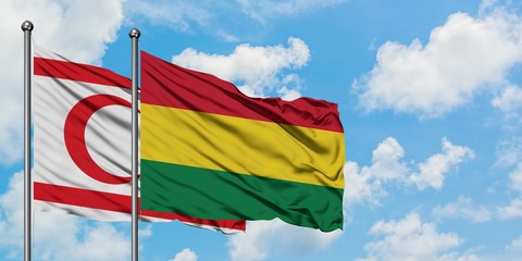 Northern Cyprus and Bolivia flag waving in the wind against white cloudy blue sky together. Diplomacy concept, international relations.